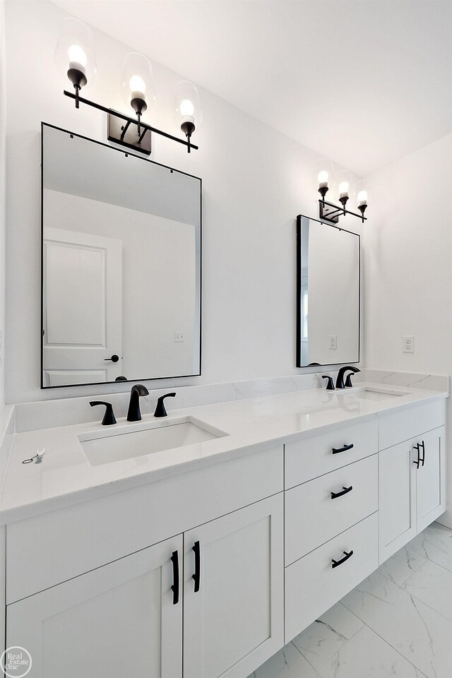 full bath with marble finish floor, a sink, and double vanity