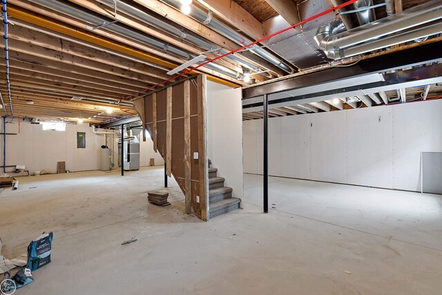 below grade area with heating unit, water heater, and stairway