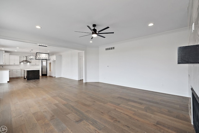 unfurnished living room with baseboards, dark wood-type flooring, a ceiling fan, and recessed lighting