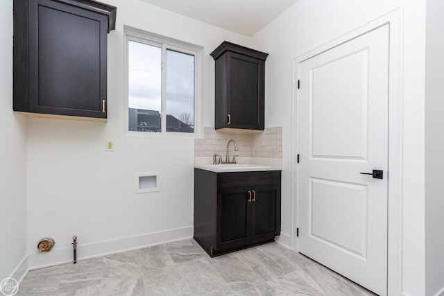 laundry area featuring gas dryer hookup, hookup for a washing machine, a sink, baseboards, and cabinet space