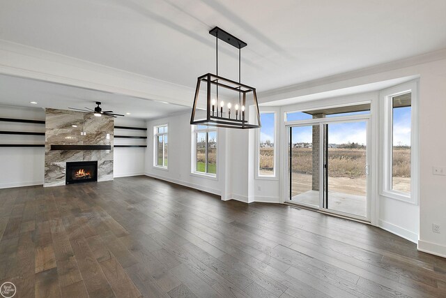 unfurnished living room with baseboards, a fireplace, ornamental molding, and dark wood-style flooring