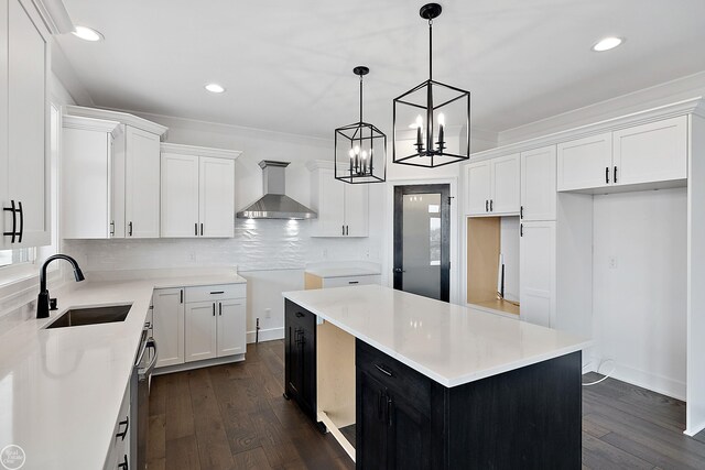 kitchen featuring wall chimney exhaust hood, a sink, dark wood finished floors, and decorative backsplash