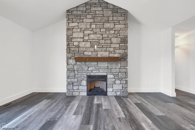 unfurnished living room with a fireplace, dark wood-type flooring, and vaulted ceiling