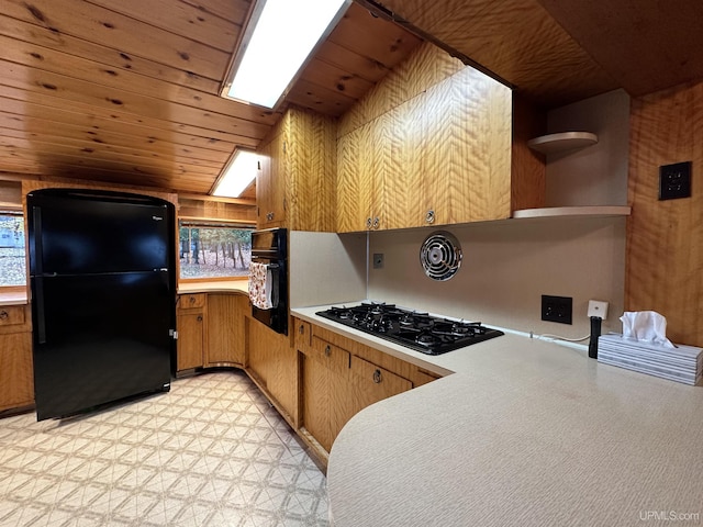 kitchen featuring black appliances, wooden walls, light tile floors, and wood ceiling