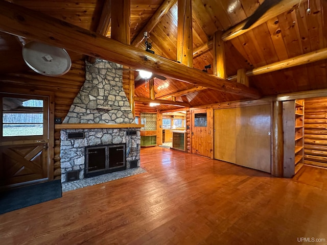 unfurnished living room featuring a fireplace, hardwood / wood-style floors, log walls, and beam ceiling