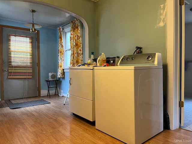 laundry room featuring washer hookup, plenty of natural light, light hardwood / wood-style floors, and washing machine and clothes dryer