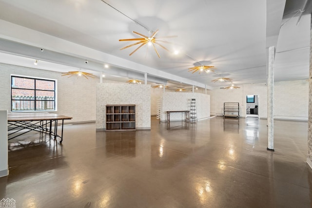 unfurnished living room featuring a fireplace, beamed ceiling, ceiling fan, and brick wall