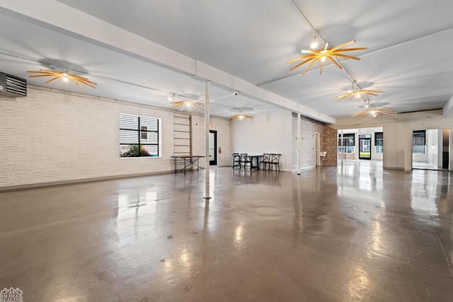 interior space featuring ceiling fan, brick wall, and a wall unit AC