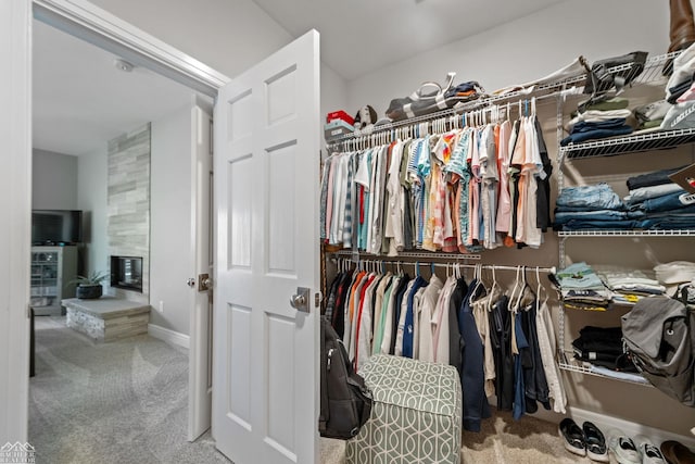 spacious closet with a tile fireplace and carpet