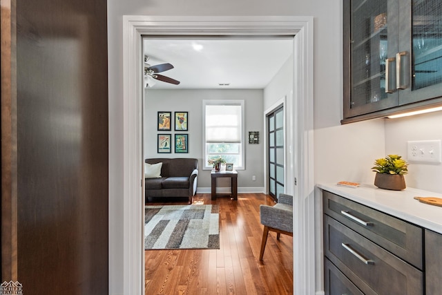 sitting room with hardwood / wood-style flooring and ceiling fan