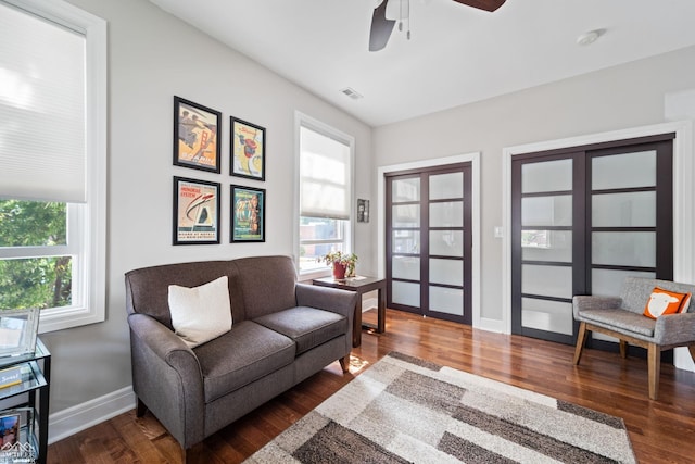 living room with dark wood-type flooring and ceiling fan