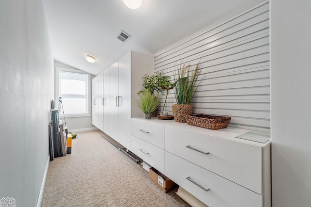 mudroom featuring lofted ceiling and light carpet