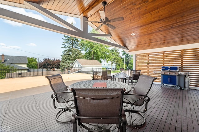 wooden terrace featuring a grill, ceiling fan, and a fire pit