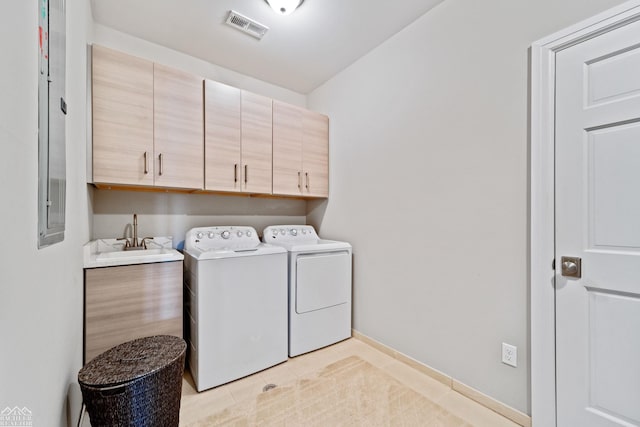 clothes washing area featuring cabinets, washer and clothes dryer, sink, and light tile patterned floors