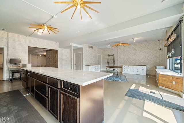 kitchen with dark brown cabinets, concrete floors, a center island, and ceiling fan