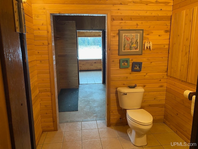 bathroom with wood walls, tile patterned flooring, and toilet