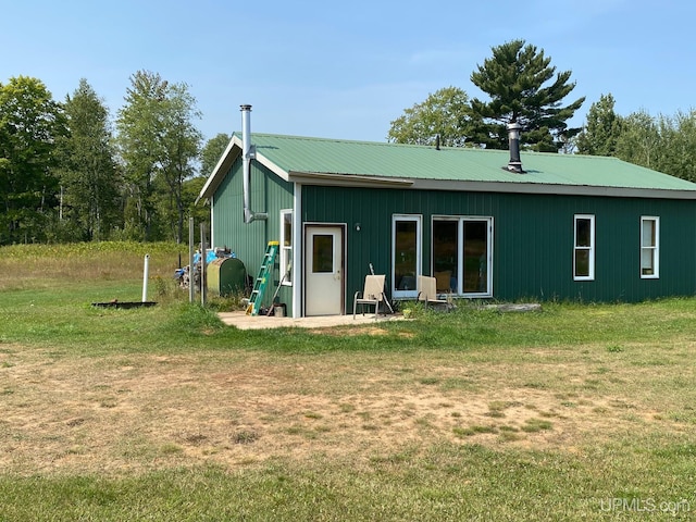 back of property featuring a lawn