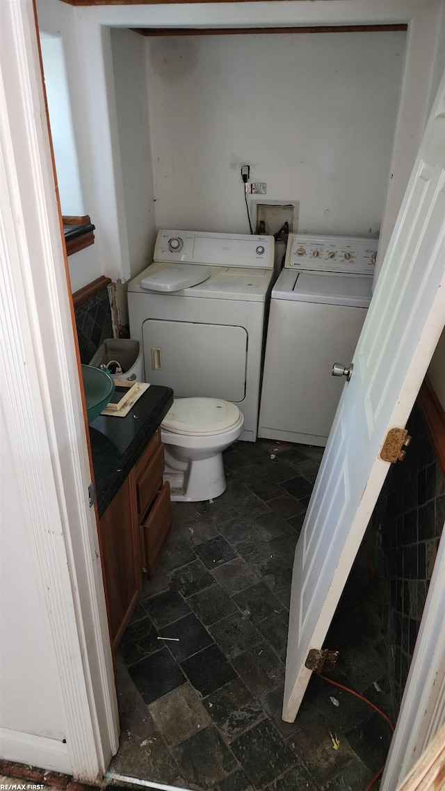 bathroom with washer and dryer, toilet, and vanity