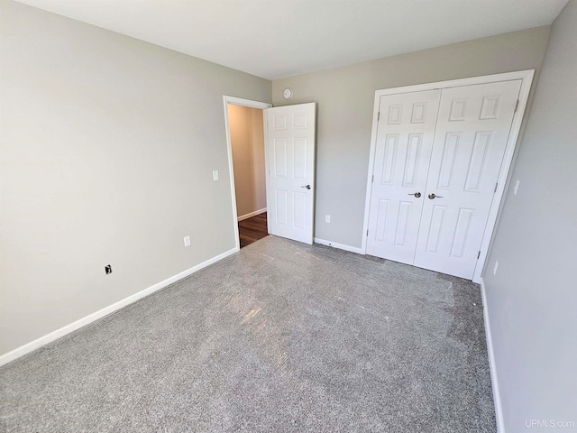 unfurnished bedroom featuring dark carpet and a closet