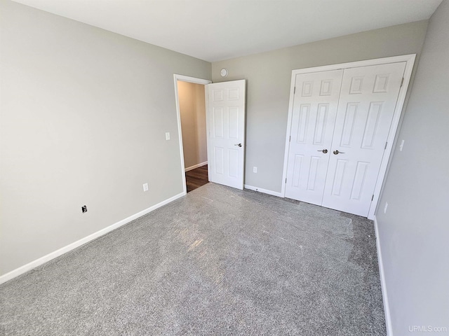 unfurnished bedroom featuring baseboards, carpet, and a closet