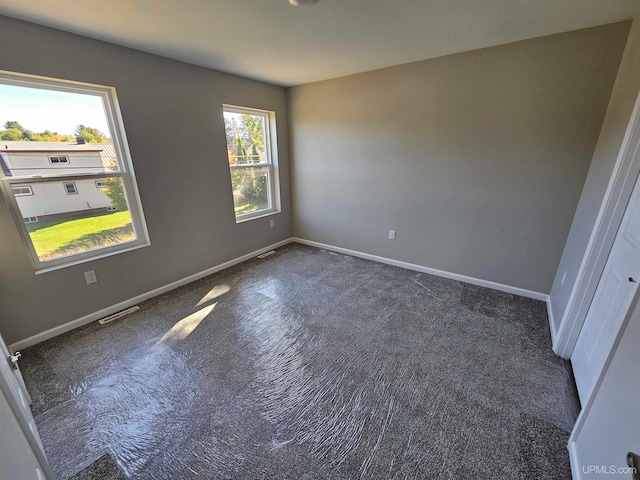 unfurnished room with dark carpet