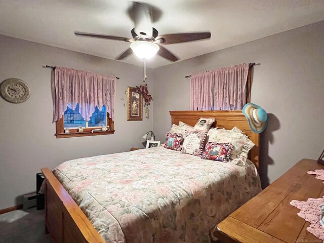 carpeted bedroom with ceiling fan and baseboard heating