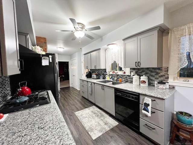 kitchen with backsplash, sink, dark hardwood / wood-style flooring, black dishwasher, and ceiling fan