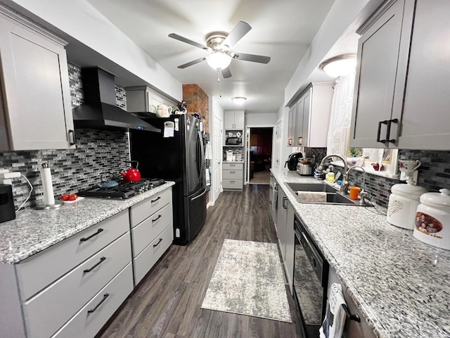 kitchen with dark hardwood / wood-style flooring, wall chimney exhaust hood, decorative backsplash, ceiling fan, and gray cabinets