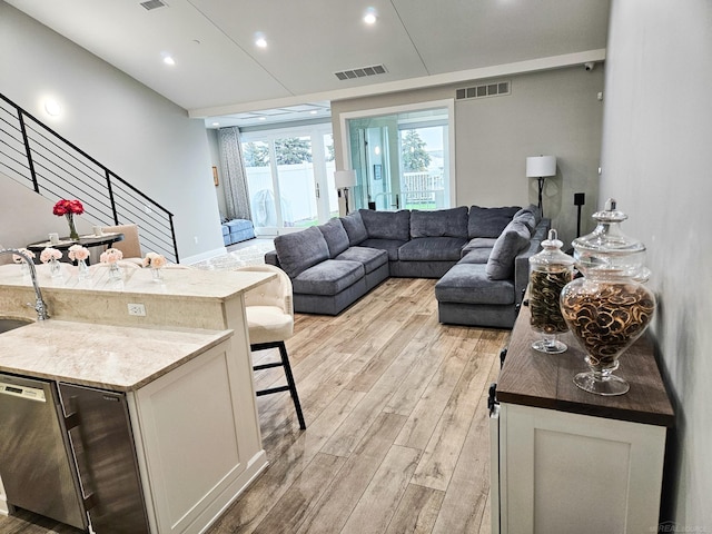 living room with sink and light hardwood / wood-style floors