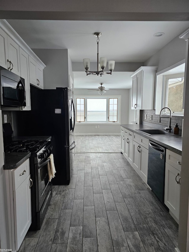 kitchen featuring white cabinetry, black appliances, a healthy amount of sunlight, and tasteful backsplash