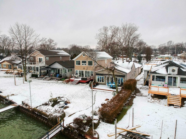 snow covered property with a sunroom and a deck