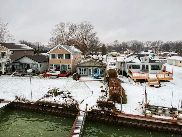 snow covered property with a deck with water view