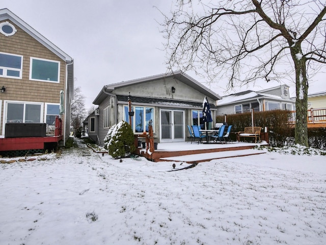 snow covered house featuring a wooden deck