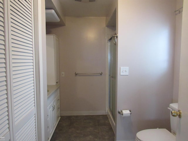 bathroom featuring vanity, a shower with shower door, and toilet