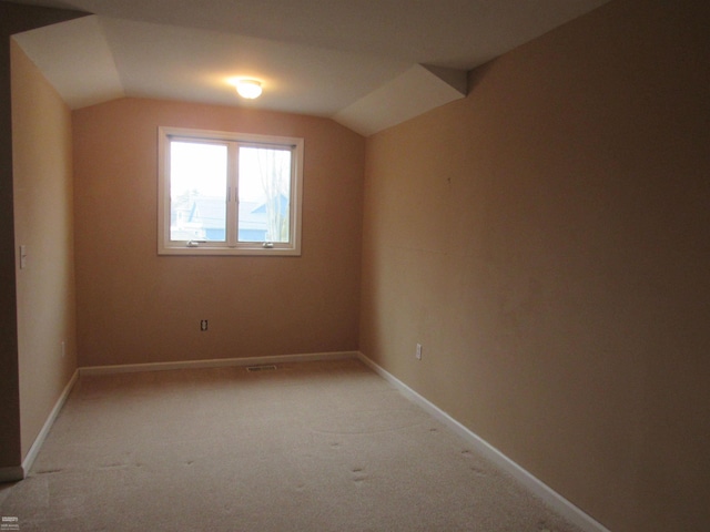 additional living space with light colored carpet and lofted ceiling