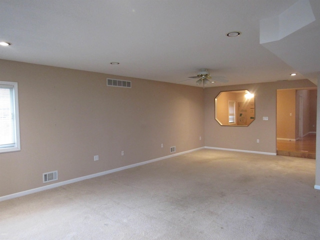 empty room featuring ceiling fan and light carpet