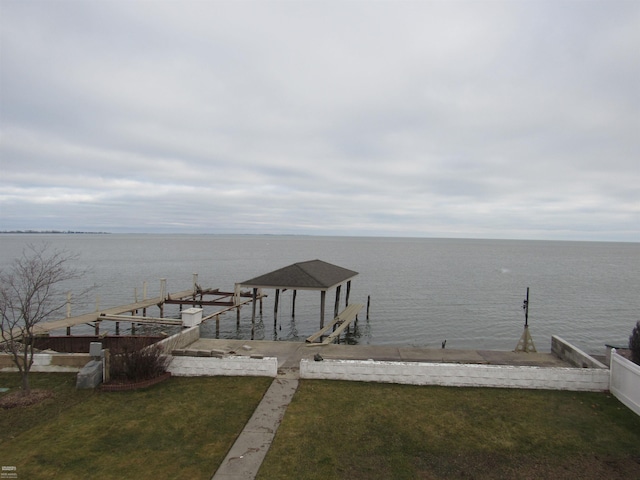 dock area with a water view and a lawn