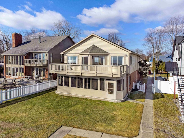 back of house featuring a balcony and a yard