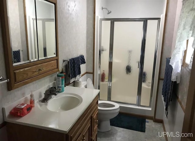 bathroom with vanity, tile floors, a shower with door, and toilet