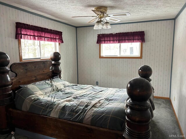 carpeted bedroom featuring a textured ceiling and ceiling fan