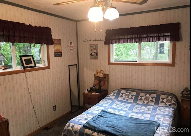 bedroom with ceiling fan and multiple windows