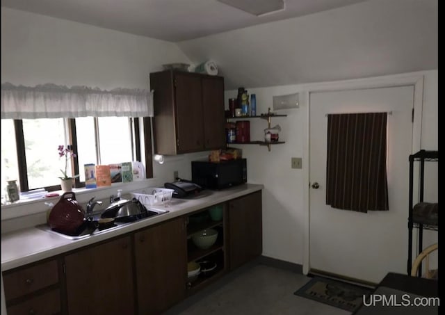 kitchen with dark tile floors and lofted ceiling