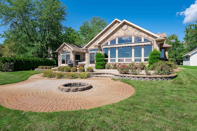 rear view of property featuring a yard and an outdoor fire pit