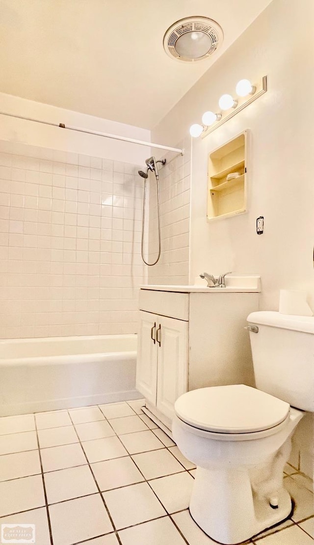 full bathroom featuring toilet, tile patterned flooring, tiled shower / bath, and vanity