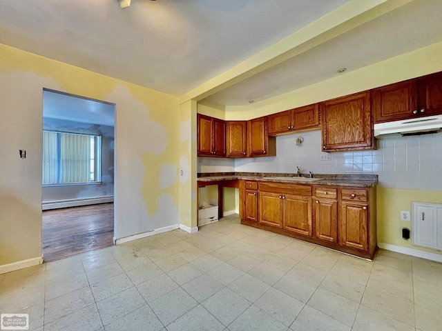 kitchen with baseboard heating, sink, and tasteful backsplash