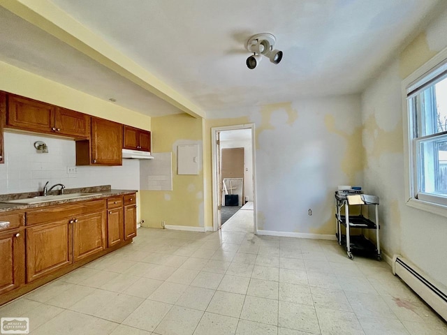 kitchen featuring decorative backsplash, a baseboard radiator, and sink