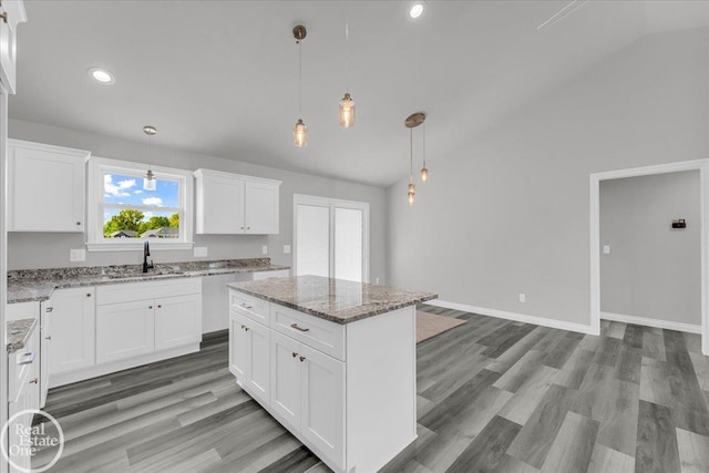 kitchen with a center island, white cabinets, decorative light fixtures, and light wood-type flooring