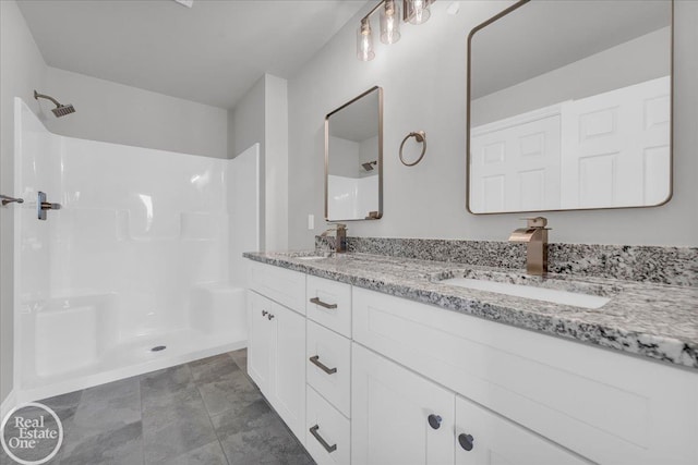 bathroom with tile patterned floors, a shower, and vanity