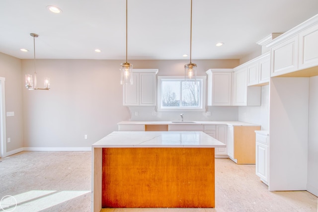 kitchen featuring white cabinetry and hanging light fixtures