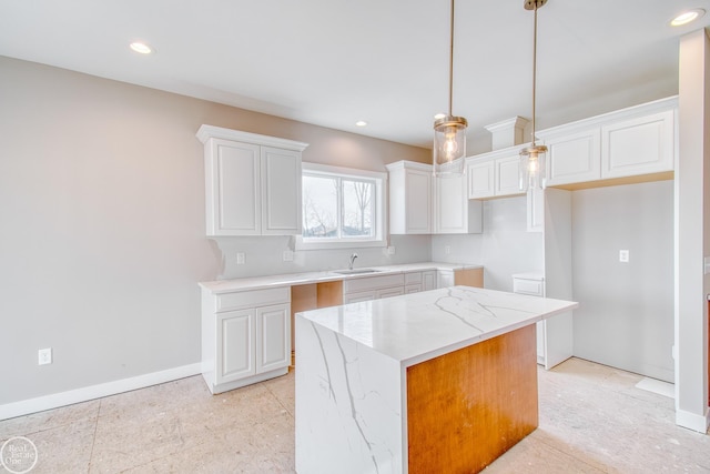 kitchen with a center island, white cabinets, decorative light fixtures, and light tile floors